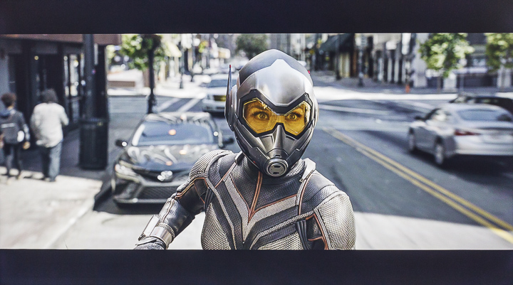 這是「蟻人與黃蜂女」中一幕，乍看就是明亮環境下的畫面，似乎沒甚麼可以吹毛求疵的地方，然而正因為環境亮度帶來明暗區域的高反差，所以大家可以仔細看看，為在畫面左側的人行道，有一片明顯在陰影中的區域，但實際上無論燈柱、垃圾桶或是建築櫥窗的線條依舊清晰，重點是再回頭看看位在日光照射下的路邊停放車輛以及黃蜂女的服裝受光面，卻沒任何過曝以至於失去細節的狀況，由此可以看出 TH-55GX750W 強大的動態範圍再現能力。