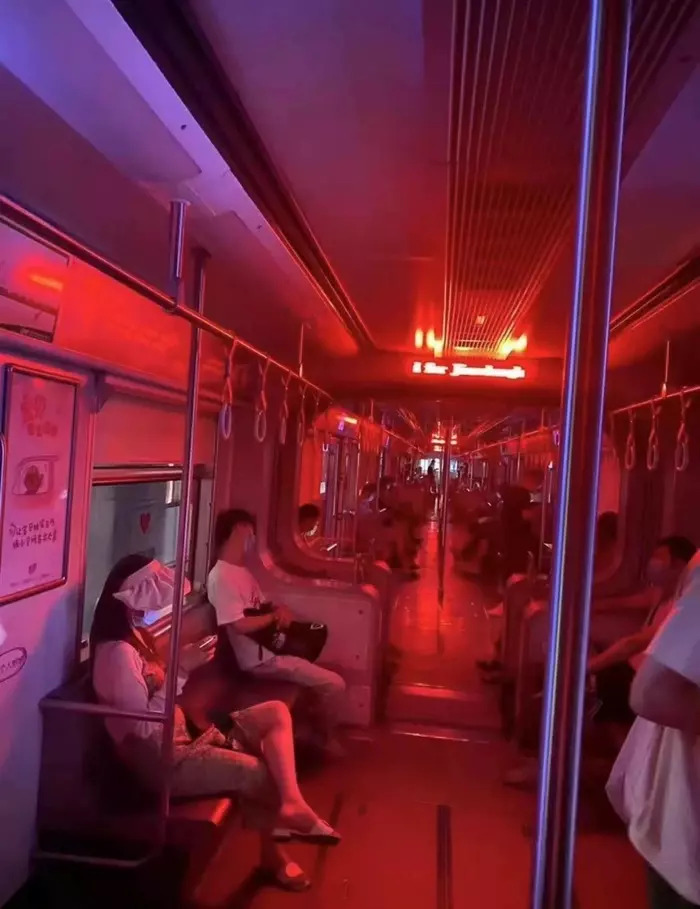 地鐵車廂內沒有開燈，但是車廂前方站牌提示螢幕，發出的為紅光，將整個地鐵「渲染」成一片通紅。
