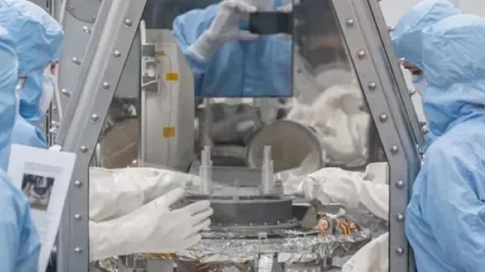 研究人員在隔著手套箱拆卸採集器。圖片來源：NASA/James Blair
