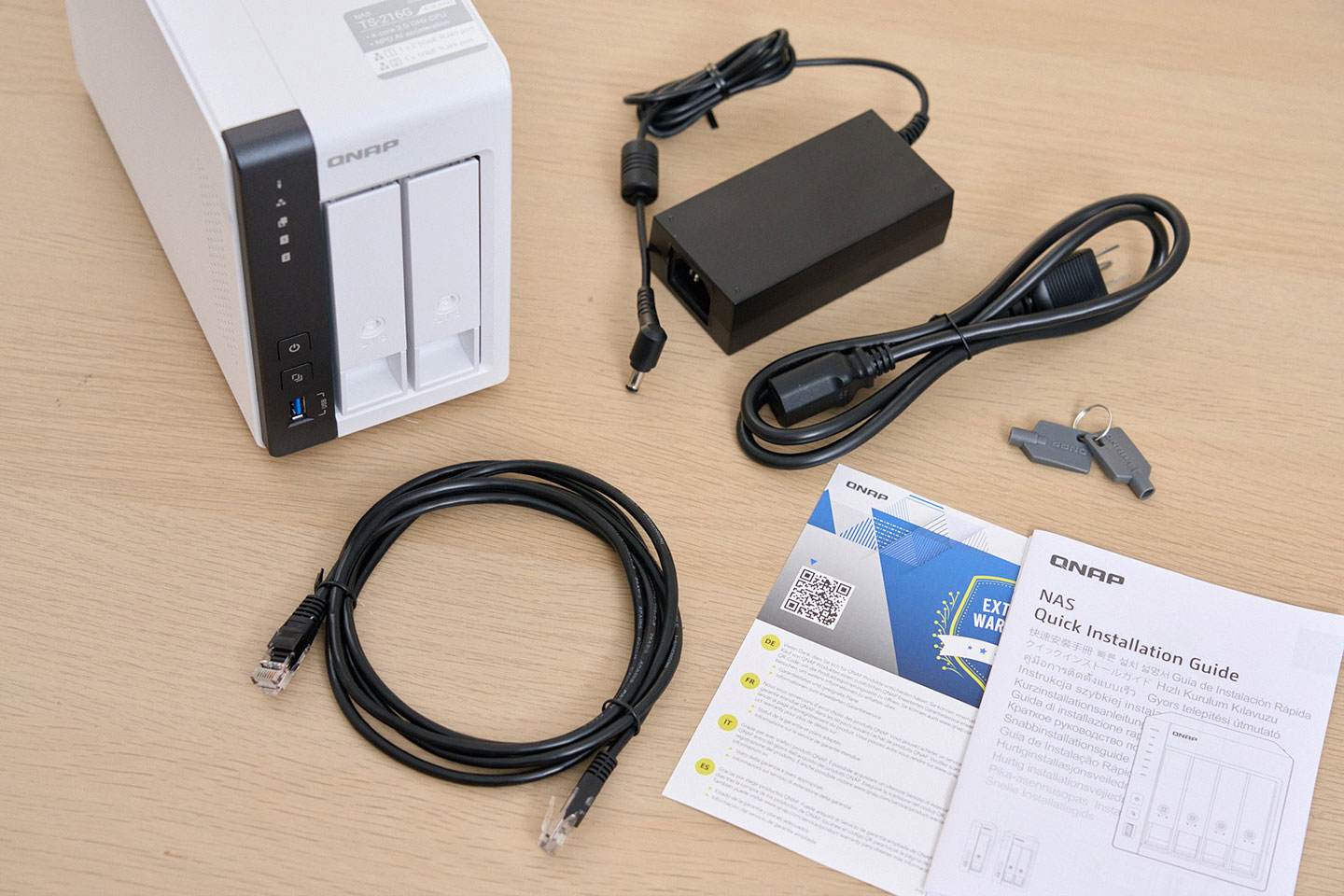 盒內所有物品一覽－包括 NAS 本體，供電器、電源線、RJ-45 網路線、硬碟槽鎖鑰匙與說明手冊。