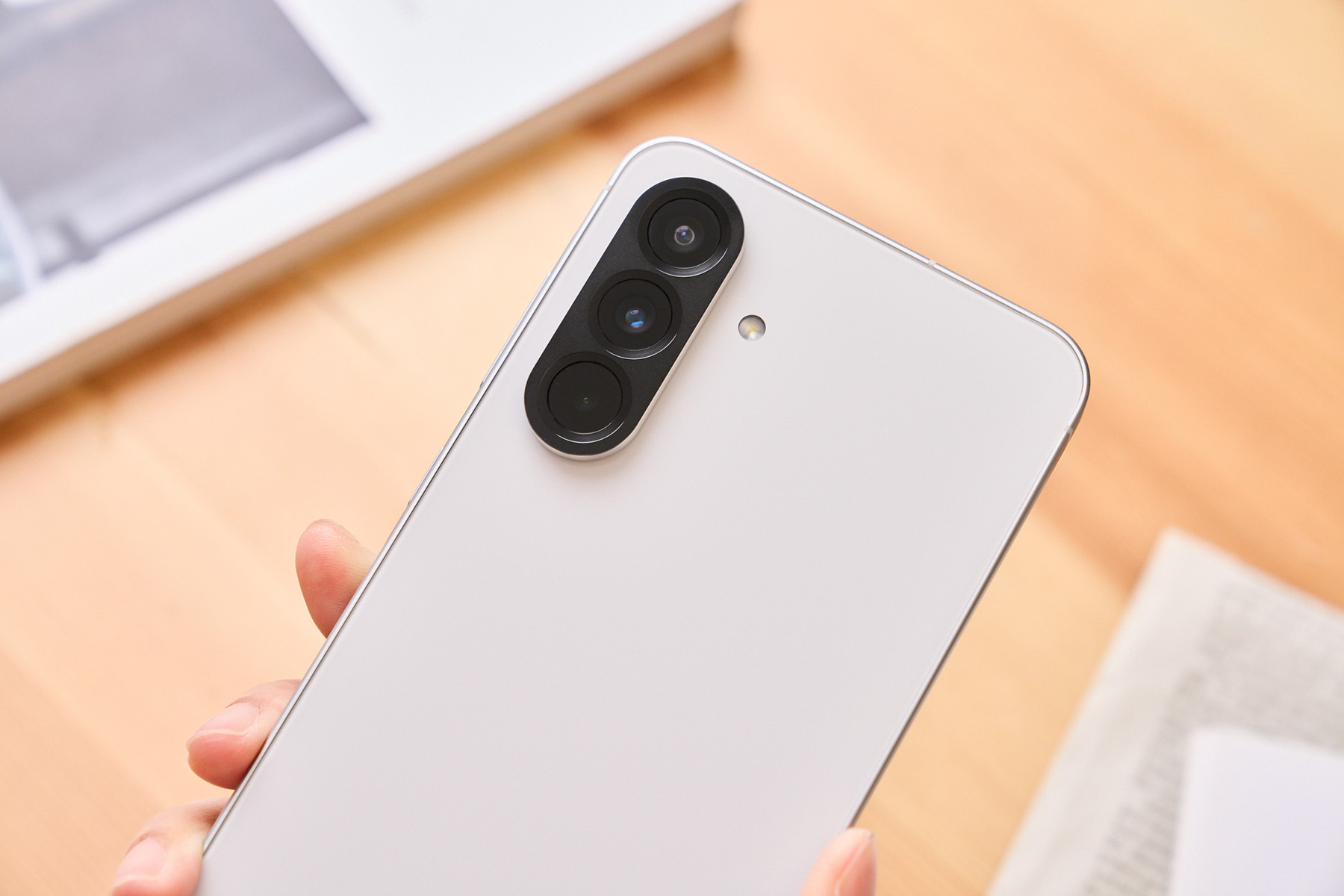Galaxy A56 相機鏡頭的排列從先前一顆一顆獨立的豆豆鏡頭改為膠囊型的鏡頭模組，沒有過多不必要的裝飾，整體顯得更加簡約俐落。