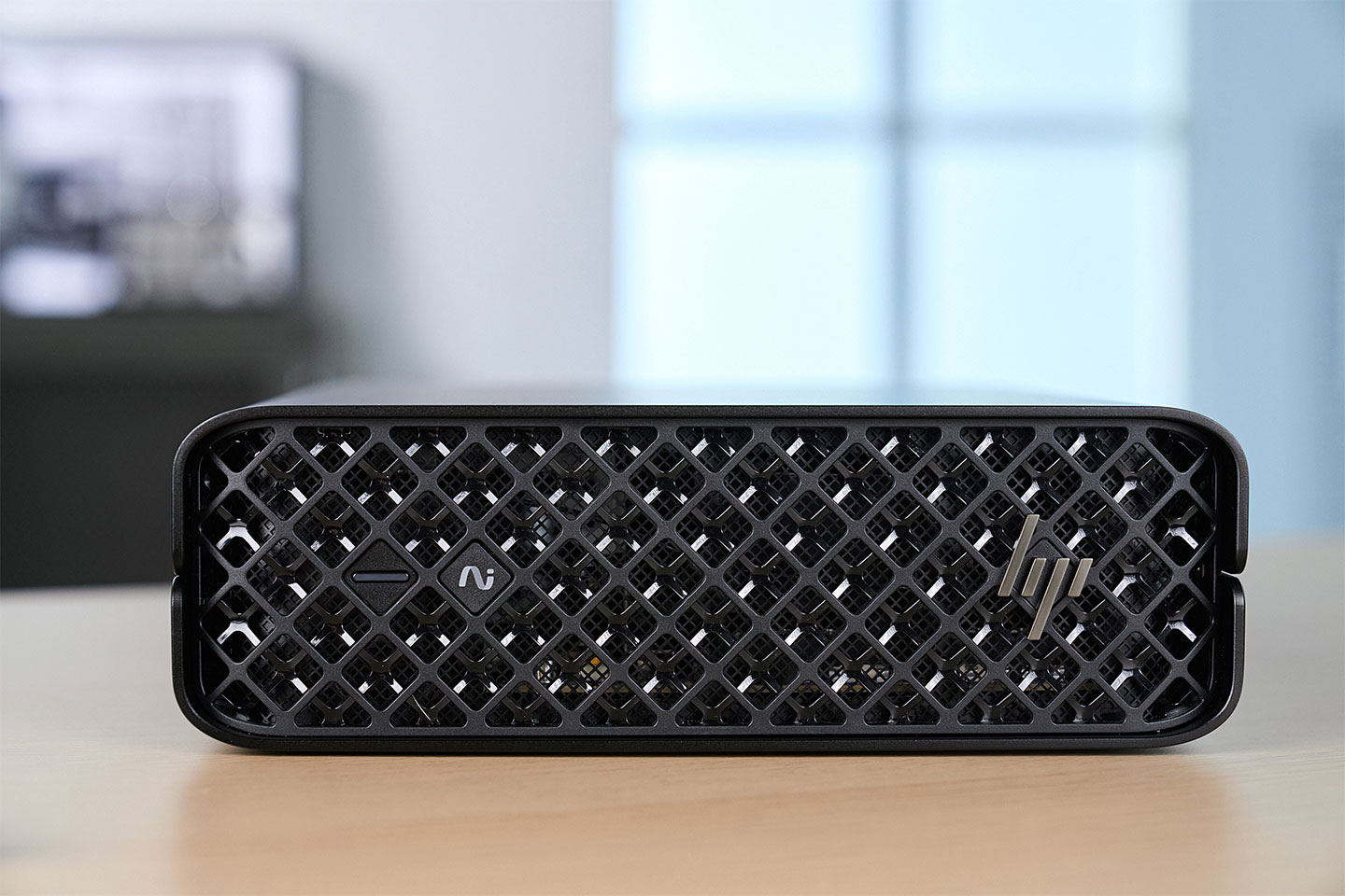 HP Z2 Mini G1i 的正面可以看到全幅的菱形格柵設計，提供良好的散熱進風效果，同時也可以看到融入於整體設計的電源鍵與指示燈號。