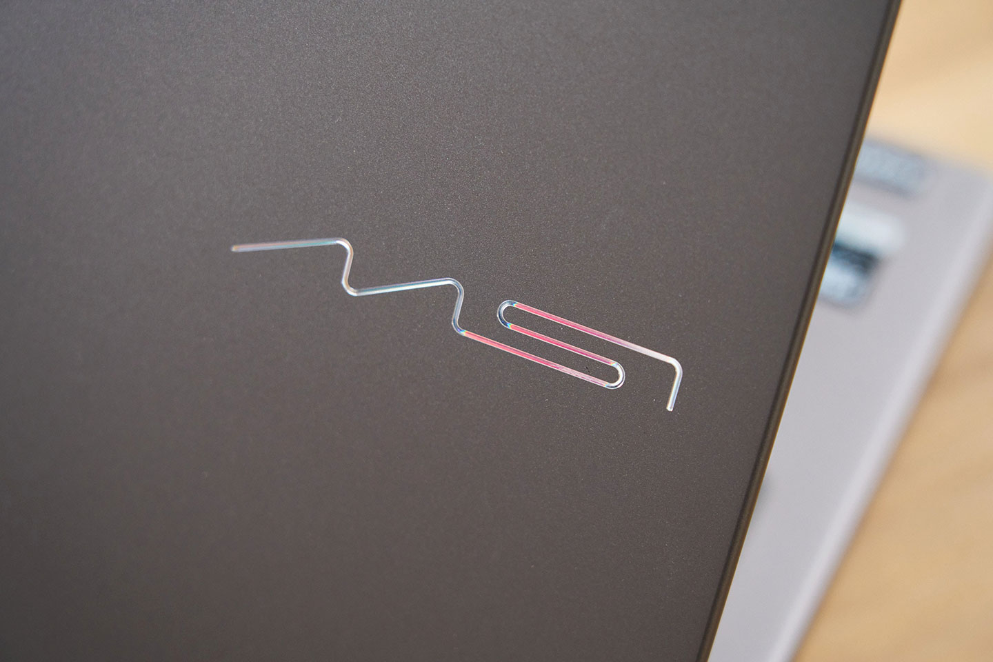 機身上蓋的全新 MSI 圖騰以流暢的弧線構成，在不同光線照射下會呈現出細微的色彩變化。