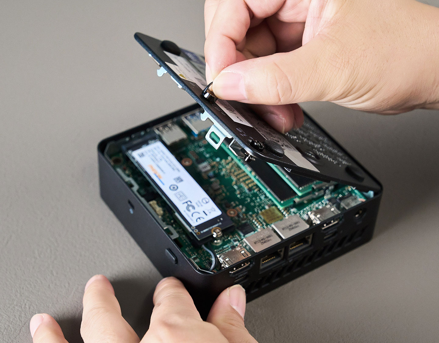 鬆開固定螺絲後，即可推動卡榫並向上拉起機身底殼。