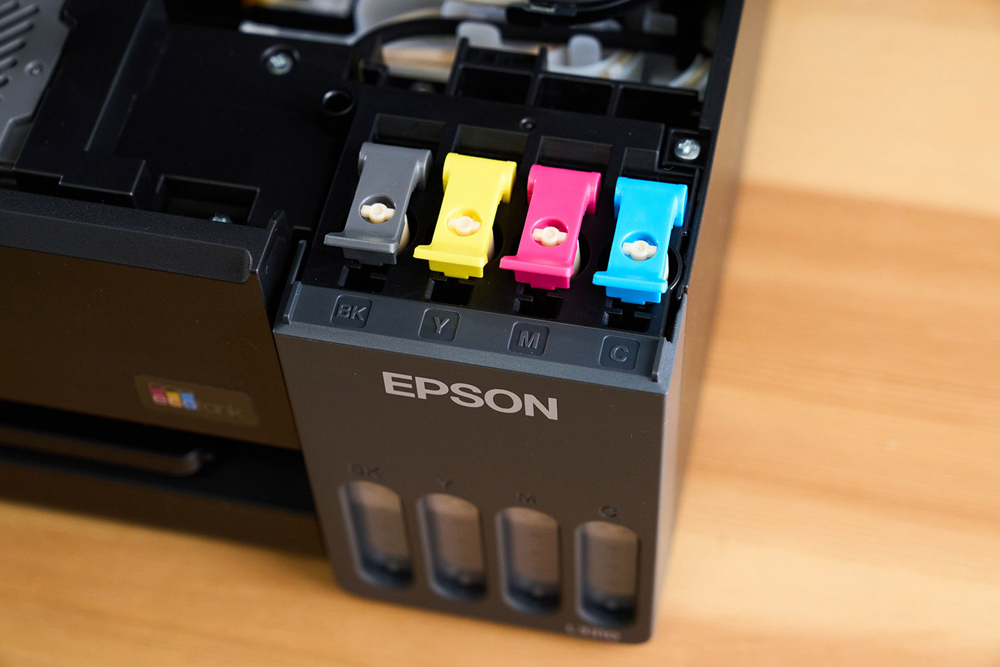 Epson L3310 的墨水槽保護蓋從過去統一藍色，改為對應四色墨水的設計，補墨時更好辨識，也降低誤加墨水的風險。