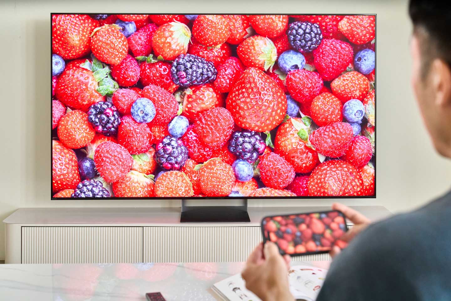 手機相簿中的照片可直接投放至 BRAVIA 大螢幕，讓行動裝置與電視無縫串接，並維持一致的色彩還原表現。即使是大面積同色系的草莓畫面，也能清楚呈現不同色階之間的細微差異。